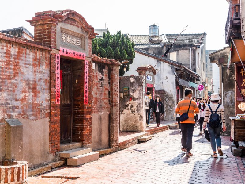 บรรยากาศถนนสายโบราณลู่กั่งที่ขนาบข้างด้วยกำแพงอิฐแดงและประตูบ้านสถาปัตยกรรมจีนโบราณที่มีมนต์ขลัง