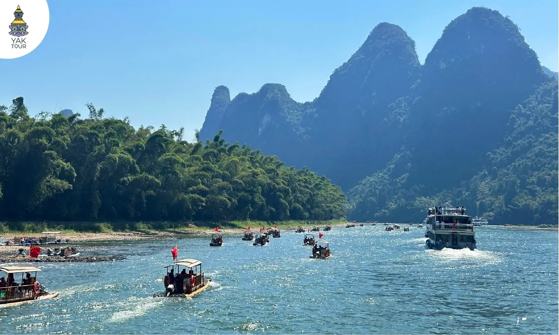 วิวเรือท่องเที่ยวและแพไม้ไผ่ล่องเรือแม่น้ำหลีเจียงผ่านทิวเขาหินปูน