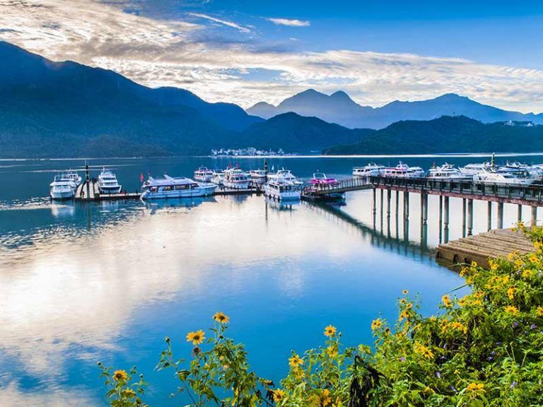 ทัศนียภาพท่าเรือริมทะเลสาบสุริยันจันทรา ท่ามกลางบรรยากาศน้ำใสสีมรกตและวิวภูเขาสลับซับซ้อน