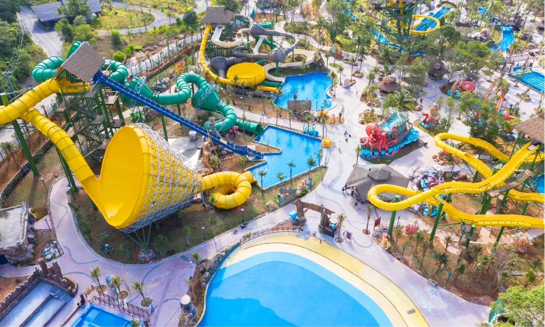 ภาพถ่ายทางอากาศ Aquatopia Water Park บนเกาะฮอนธอม แสดงสไลเดอร์ขนาดใหญ่หลากสีและสระน้ำธีมมหาสมุทร