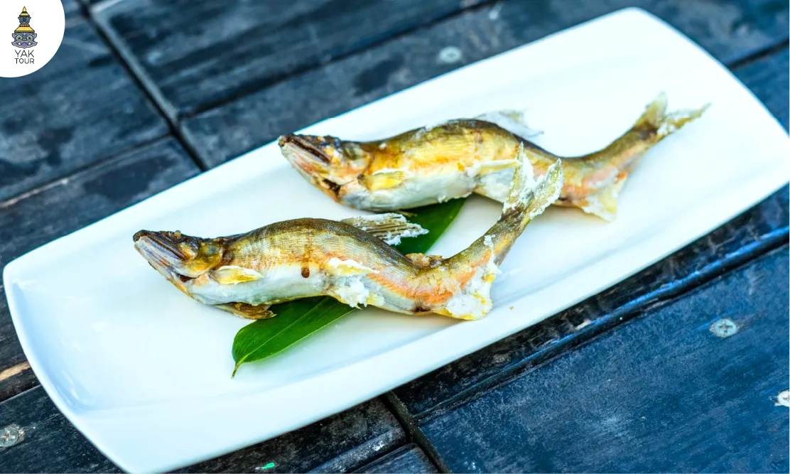 เมนูปลาย่างเกลือเลิศรสจัดเสิร์ฟบนจานสีขาวในย่านร้านอาหารของ Gujo Hachiman