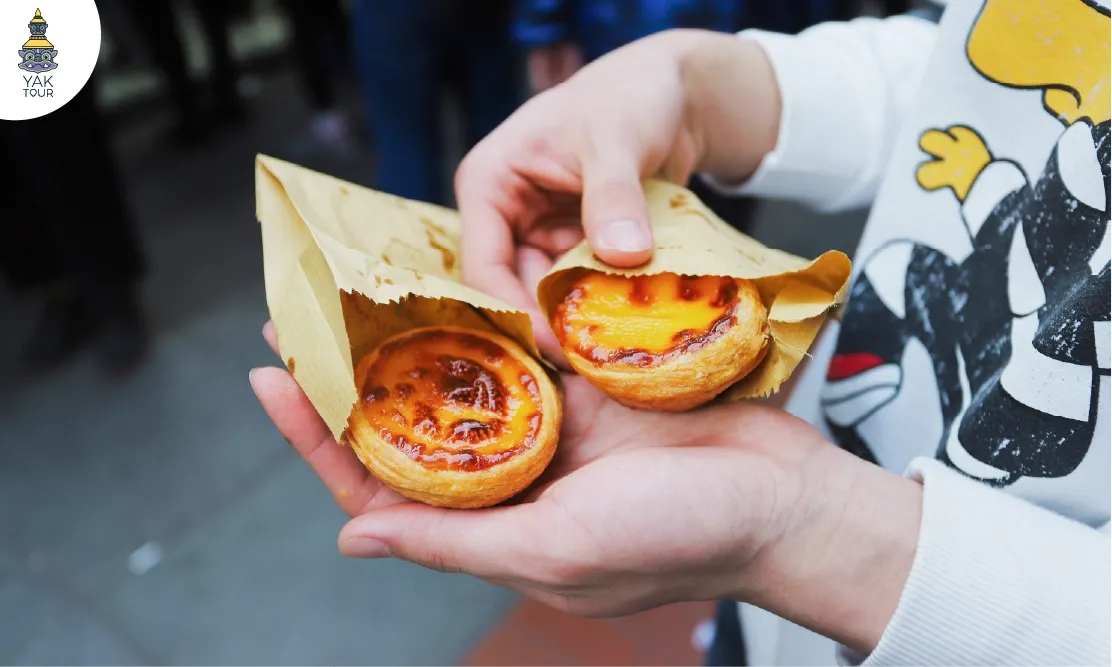 Close-up ทาร์ตไข่ซาวโดว์หน้าไหม้ Sourdough Egg Tart ถือหน้าหน้าร้าน Bakehouse