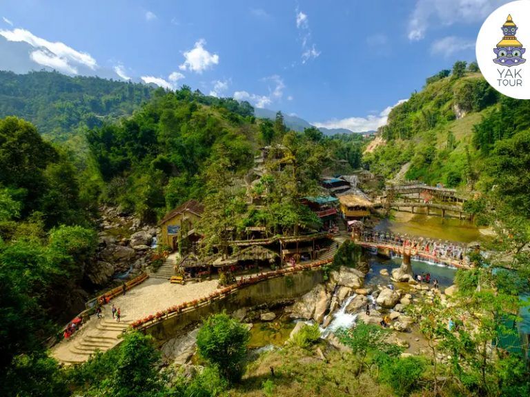 บรรยากาศหมู่บ้านกั๊ตกั๊ตที่มีบ้านไม้โบราณตั้งอยู่ริมลำธารและน้ำตก รายล้อมด้วยสะพานไม้และทางเดินท่ามกลางหุบเขาเขียวขจีในซาปา