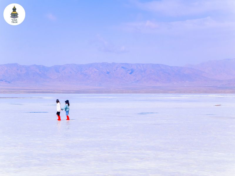 ผืนน้ำที่ใสสะอาดและตื้นเขินปกคลุมไปด้วยผลึกเกลือสีขาวบริสุทธิ์ของทะเลสาบเกลือฉาข่า