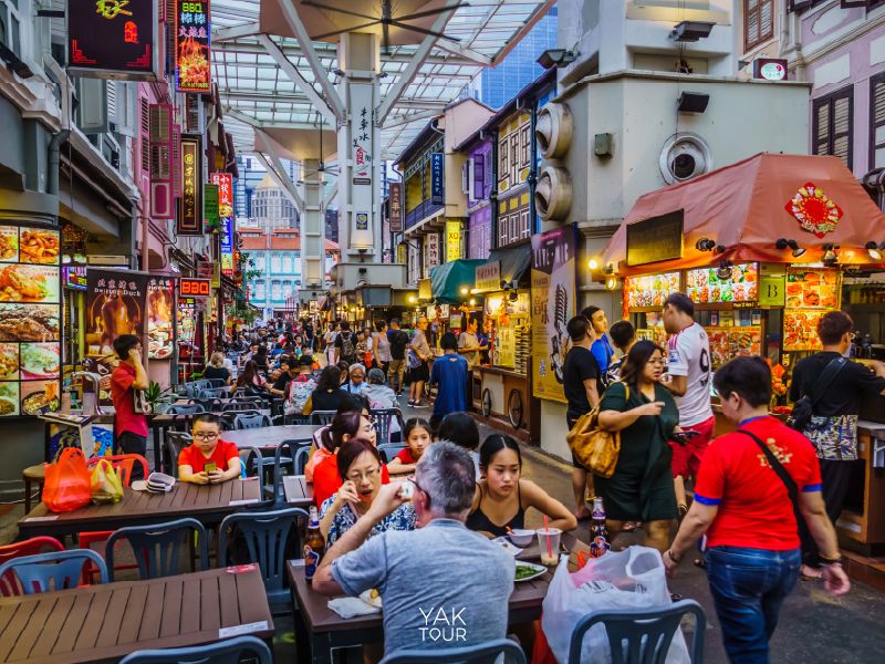 บรรยากาศร้านอาหารสตรีทฟู้ดสุดคึกคักในย่านไชน่าทาวน์สิงคโปร์ พร้อมอาคารตึกแถวสีสันสดใส