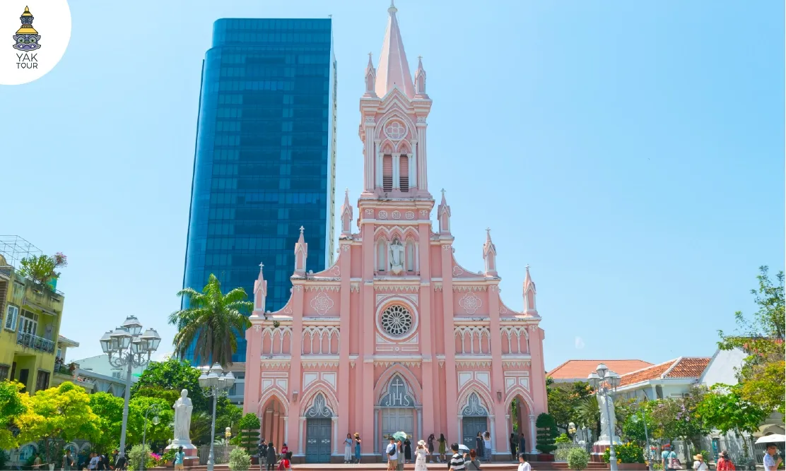 โบสถ์คริสต์สีชมพู (Da Nang Cathedral) ดานัง สถาปัตยกรรมสีชมพูพาสเทลทรงยุโรป มีหอคอยยอดแหลมสูงตระหง่านตัดกับอาคารสมัยใหม่ในพื้นหลัง