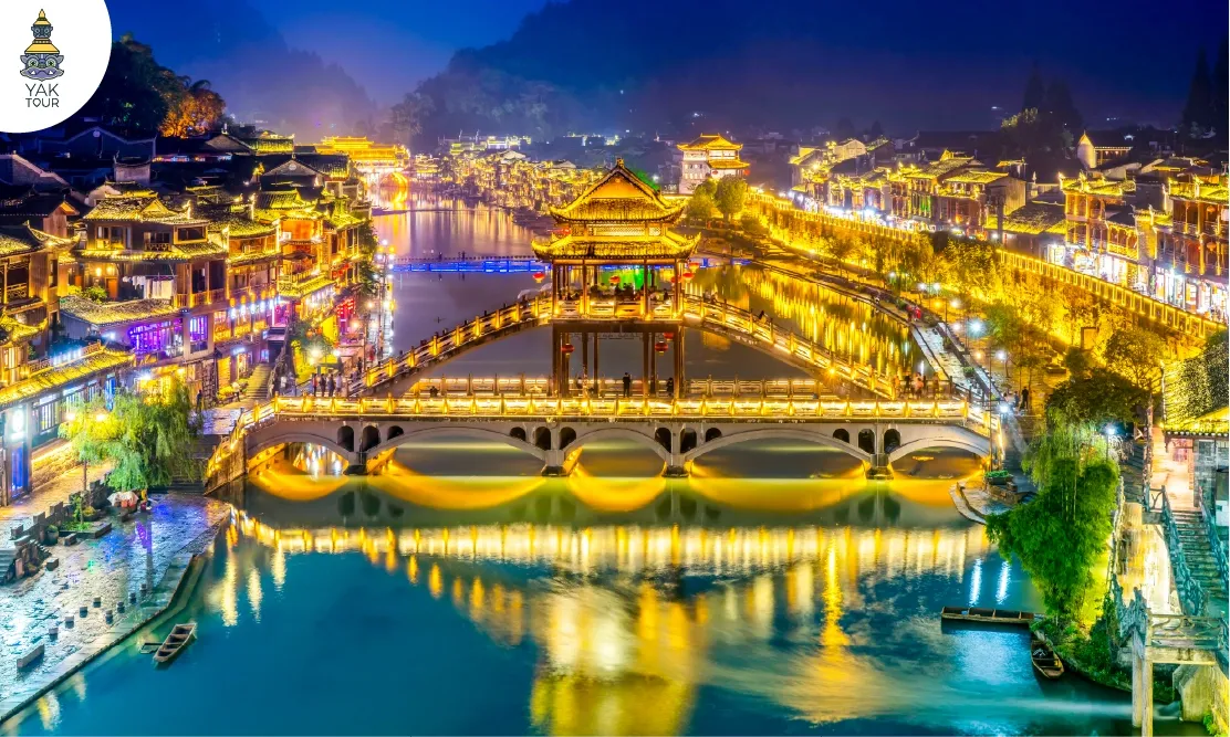 วิวเปิดไฟยามค่ำคืนของเมืองโบราณเฟิ่งหวงและสะพานข้ามแม่น้ำถัวเจียง
