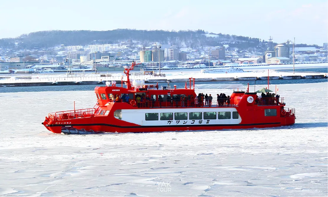 เรือตัดน้ำแข็ง Garinko II สีแดงสดขณะล่องตัดผ่านแผ่นน้ำแข็งสีขาวกลางทะเลฮอกไกโด