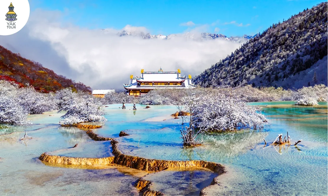 วิวสระน้ำหินปูนสีฟ้าใสและวัดโบราณหวงหลง ท่ามกลางหิมะและทะเลหมอก