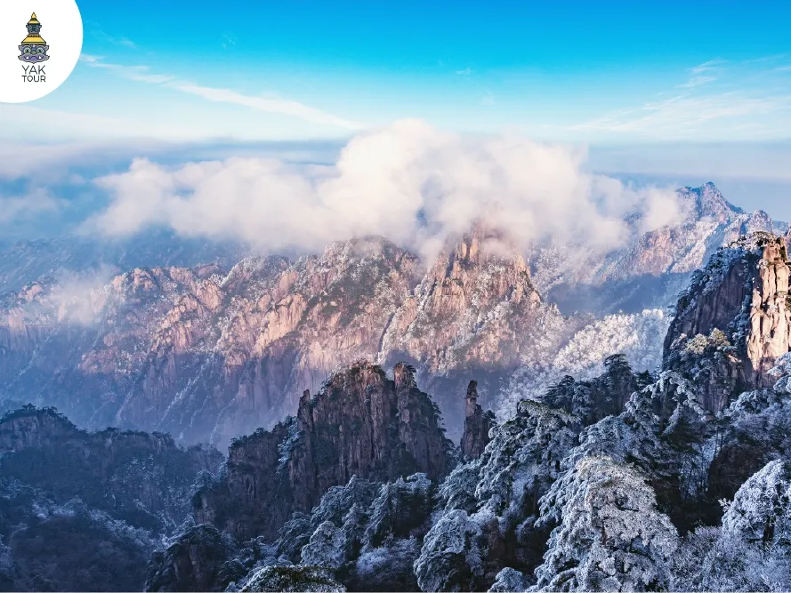 ทัศนียภาพต้นสนและยอดเขาหินแกรนิตปกคลุมด้วยเกล็ดน้ำแข็งบนเขาหวงซาน