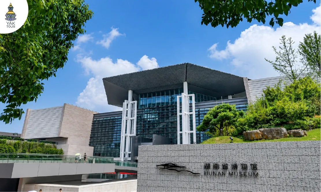อาคารโมเดิร์นสีเทาด้านหน้าพิพิธภัณฑ์มณฑลหูหนาน (Hunan Museum) พร้อมป้ายชื่อภาษาจีนและอังกฤษ
