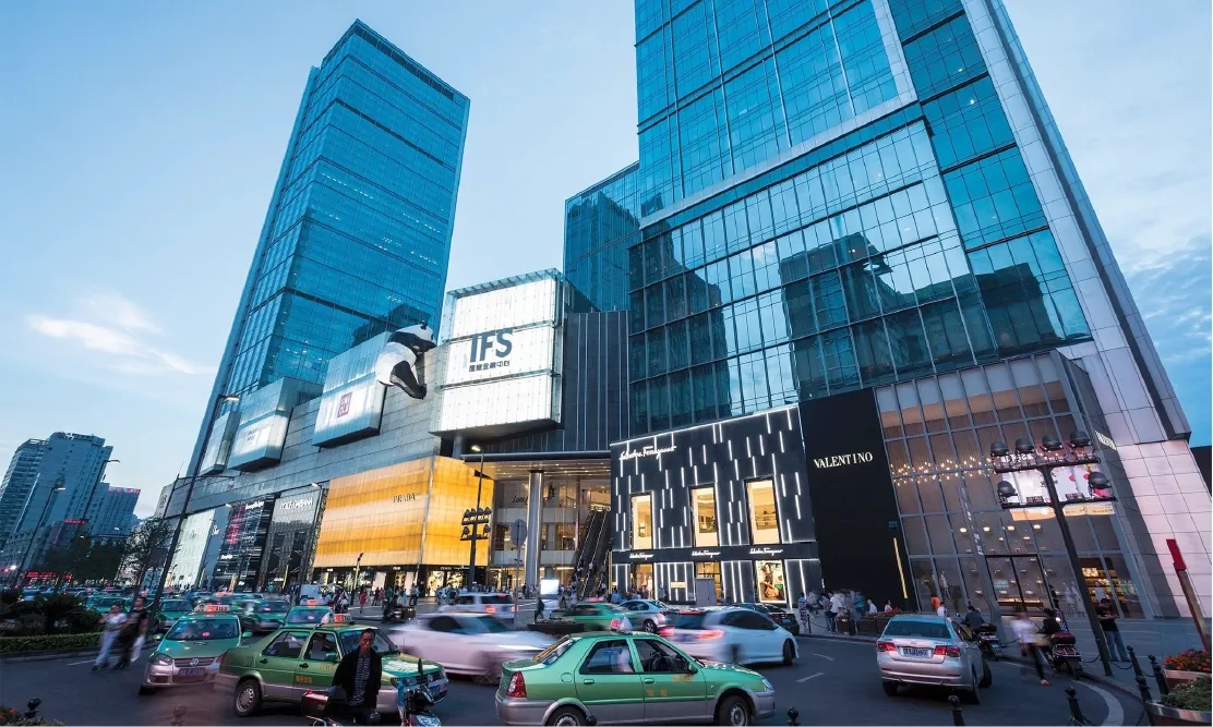 รูปปั้นแพนด้าปีนตึก IFS Tower ฉงชิ่ง ยามเย็น เห็นป้าย IFS ชัดเจน