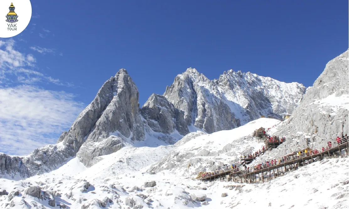 ทางเดินไม้ชมวิวบนยอดเขาหิมะมังกรหยก ท่ามกลางหิมะขาวและท้องฟ้าใส