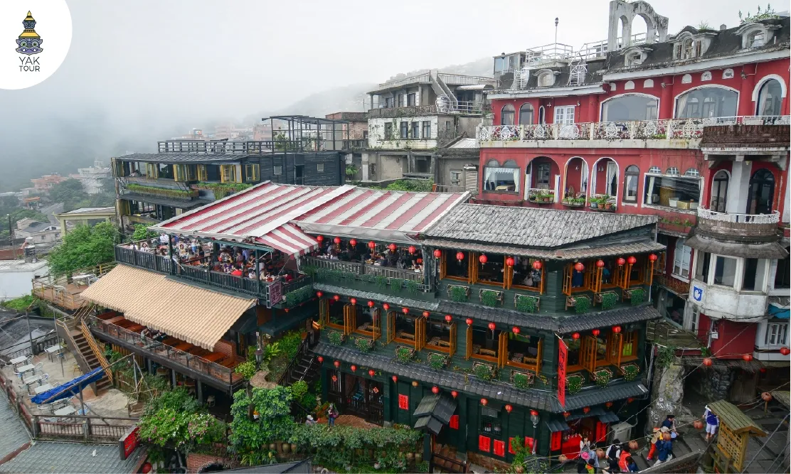 อาคารไม้เก่าแก่ประดับโคมไฟสีแดงและไอหมอกที่หมู่บ้านโบราณจิ่วเฟิ่น