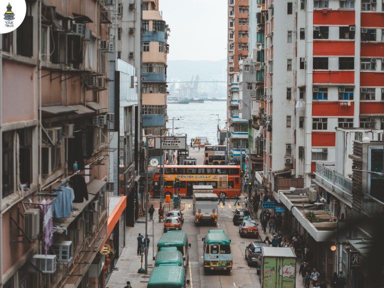 วิวถนนสุดสายที่มองเห็นทะเลและท่าเรือผ่านช่องว่างระหว่างตึกแถวเก่าแก่ในย่านเคนเนดี้ทาวน์