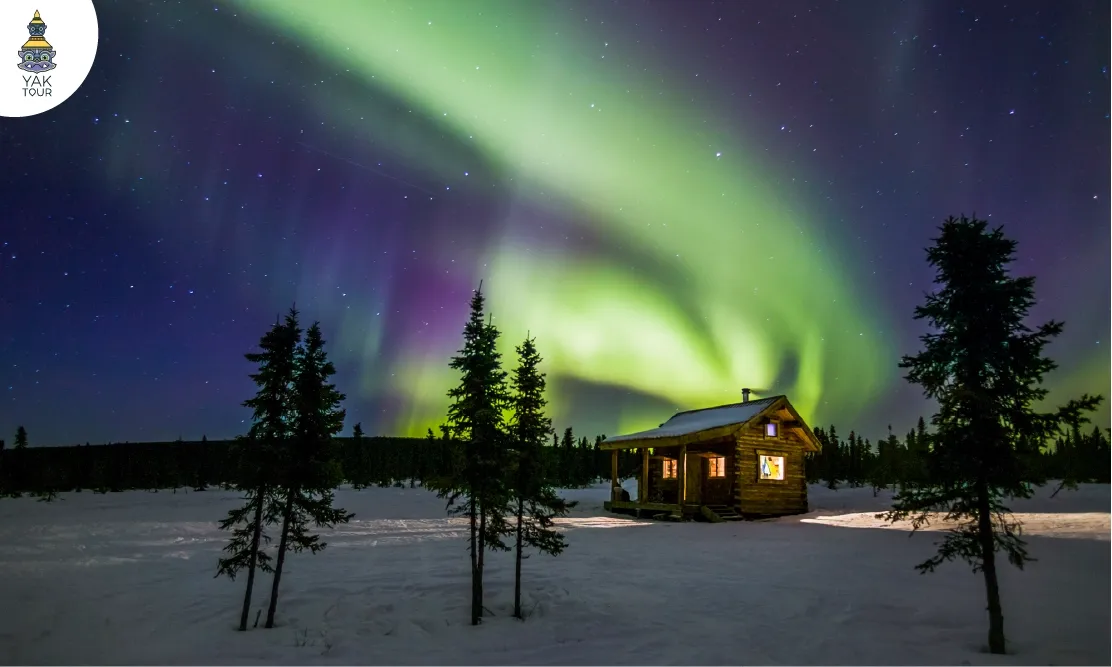บ้านกระท่อมไม้ซุง Log Cabin ท่ามกลางทุ่งหิมะและม่านแสงออโรร่าสีเขียวอมม่วงที่ลองเยียร์เบียน