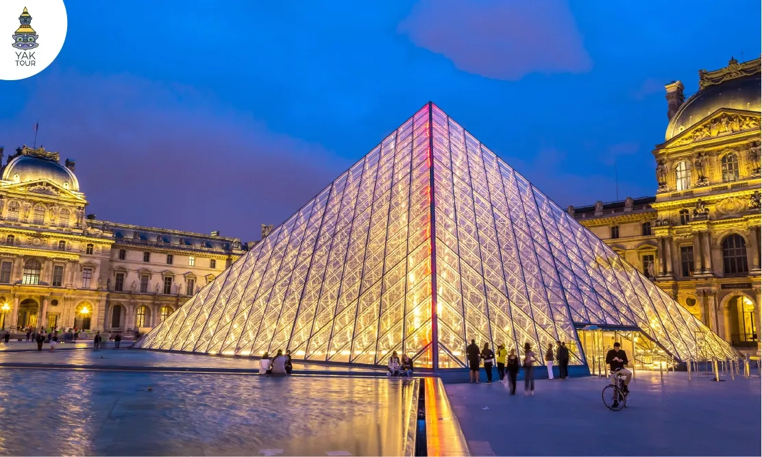 พีระมิดแก้วสะท้อนน้ำยามค่ำคืนด้านหน้า Louvre Museum หนึ่งในพิพิธภัณฑ์ที่ดีที่สุดในโลก