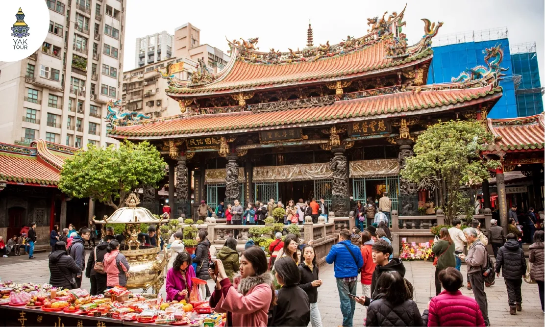 สถาปัตยกรรมหลังคาวัดอันประณีตและบรรยากาศผู้คนกราบไหว้ขอพรที่วัดหลงซาน