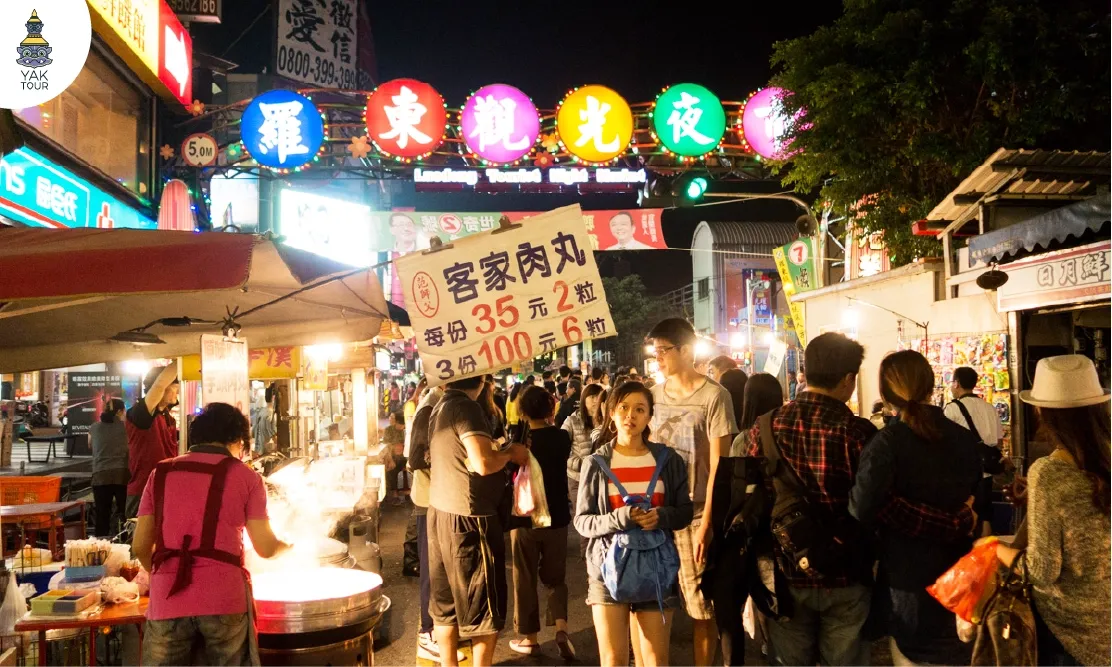 บรรยากาศความคึกคักและป้ายไฟทางเข้าตลาดกลางคืนหลัวตงยามค่ำคืน