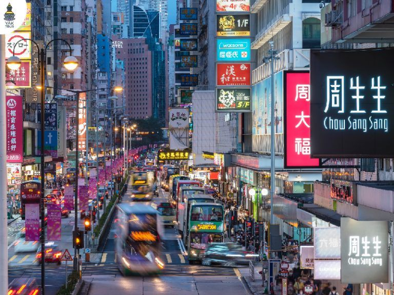 บรรยากาศความคึกคักบนถนนย่านมงก๊กที่มีป้ายไฟร้านค้าเรียงรายและเต็มไปด้วยชีวิตชีวาและสีสันตลอดทั้งวันทั้งคืน