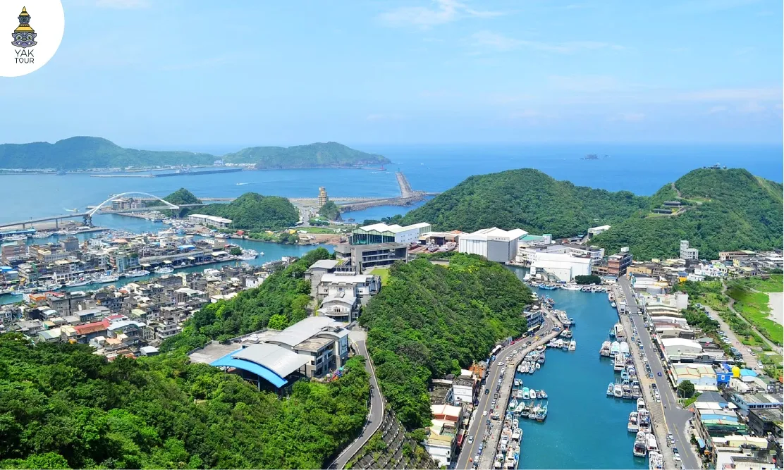 ทัศนียภาพมุมสูงมองเห็นท่าเรือประมงและอ่าวโค้งที่จุดชมวิวหนานฟางอ้าว