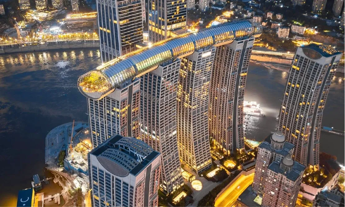 วิวโดรน Raffles City Chongqing ยามค่ำคืน เห็นสะพานลอยฟ้า The Crystal ชัดเจน