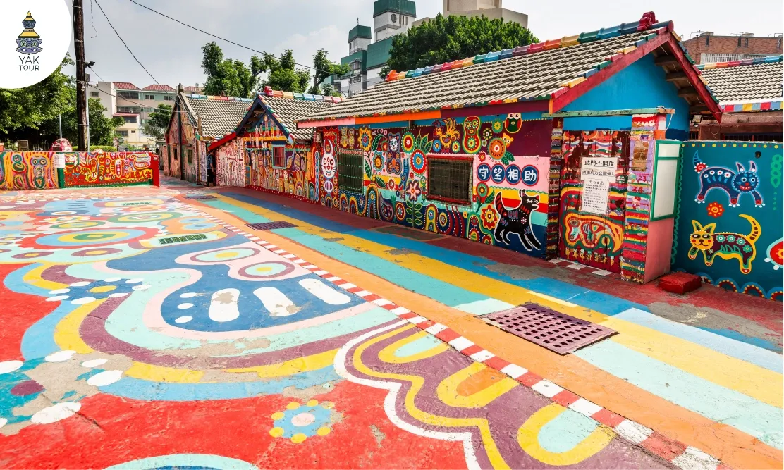 ลวดลายภาพวาดสีสันสดใสบนพื้นถนนและผนังบ้านในหมู่บ้านสายรุ้งเมืองไทจง