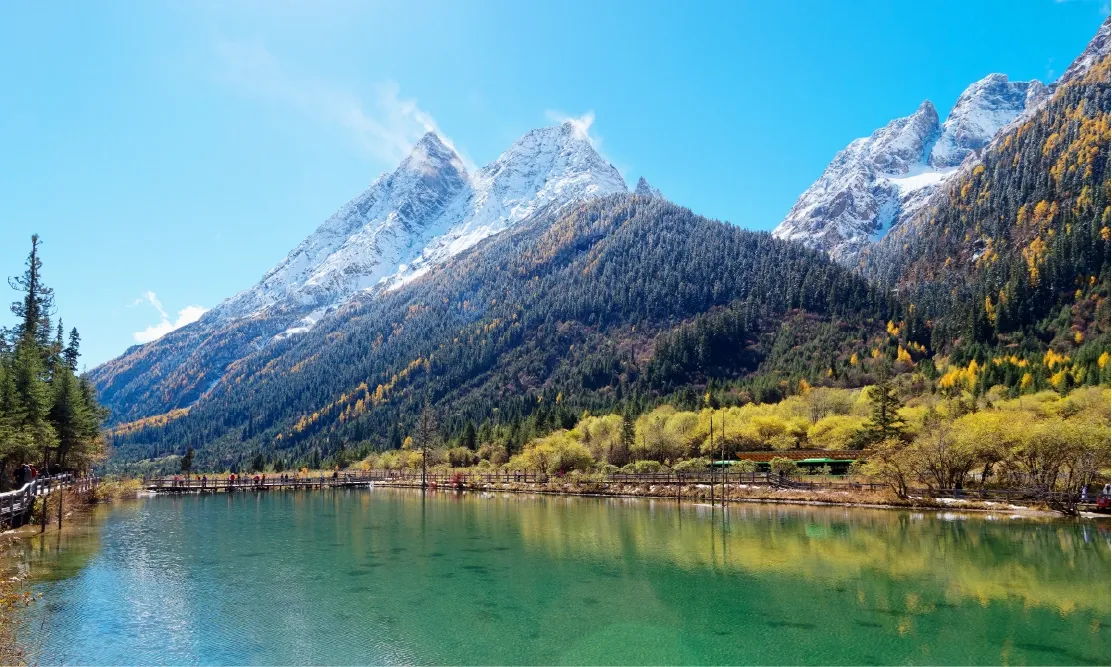 วิวทุ่งหญ้าและยอดเขาหิมะรูปทรงพีระมิดที่เขาสี่ดรุณี