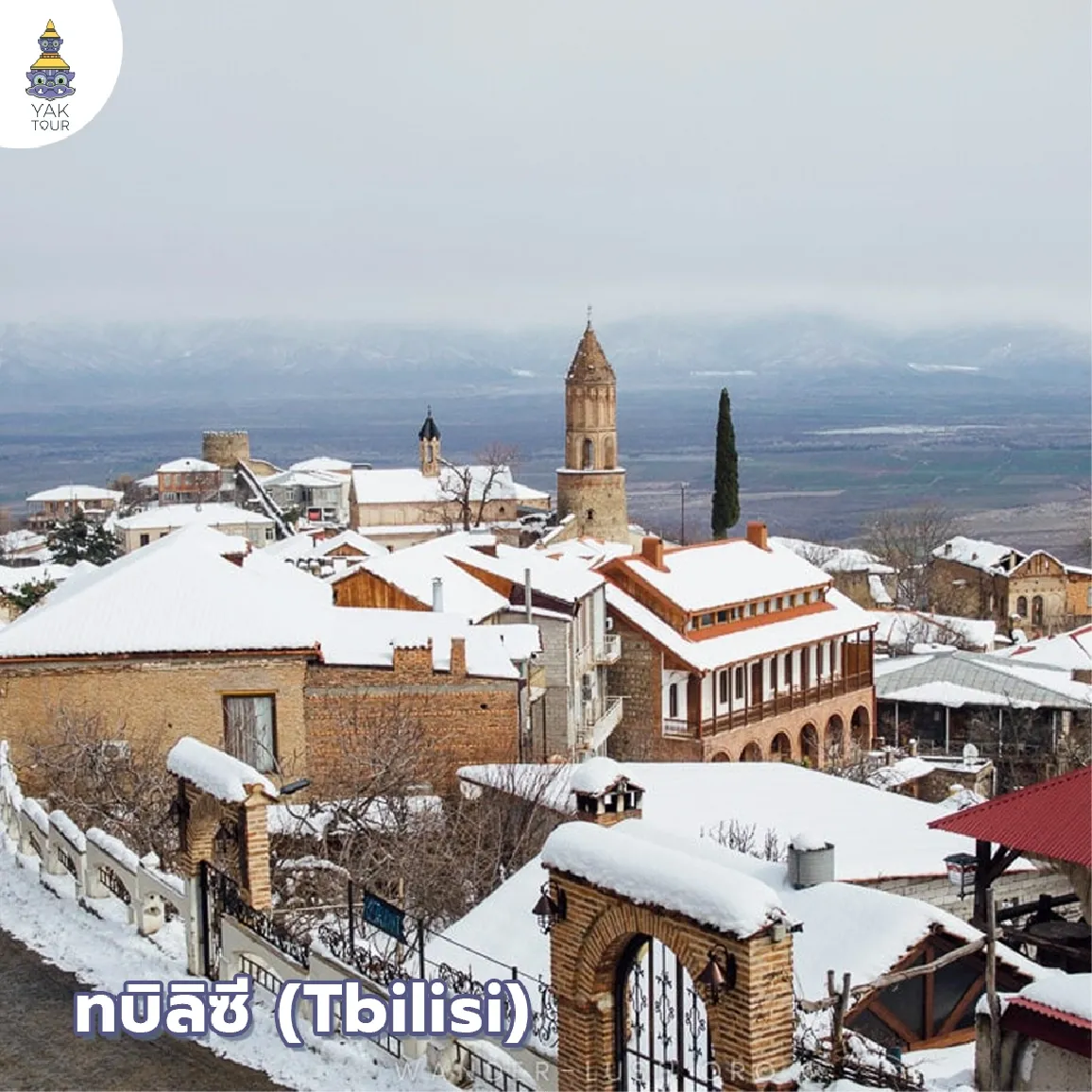 ทัศนียภาพมุมสูงของย่านเมืองเก่าทบิลิซีและหลังคาสีส้มที่ถูกคลุมด้วยหิมะ