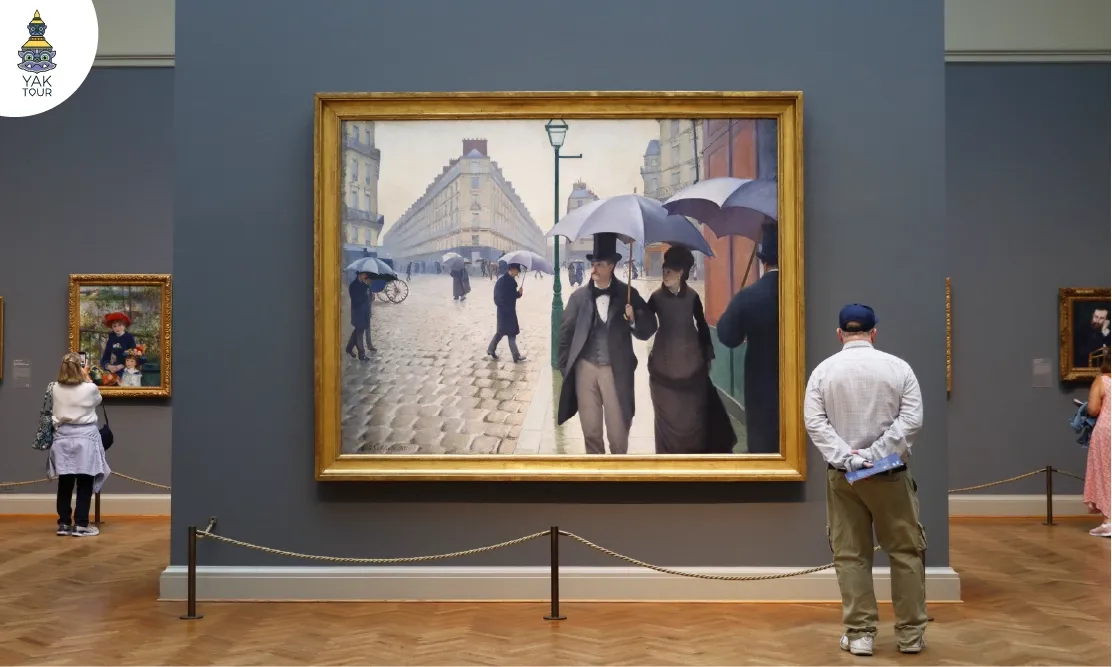 ภาพวาดปารีสในวันฝนตกและงานประติมากรรมสำริดที่จัดแสดงโดดเด่นกลางห้องนิทรรศการภายใน The Art Institute of Chicago
