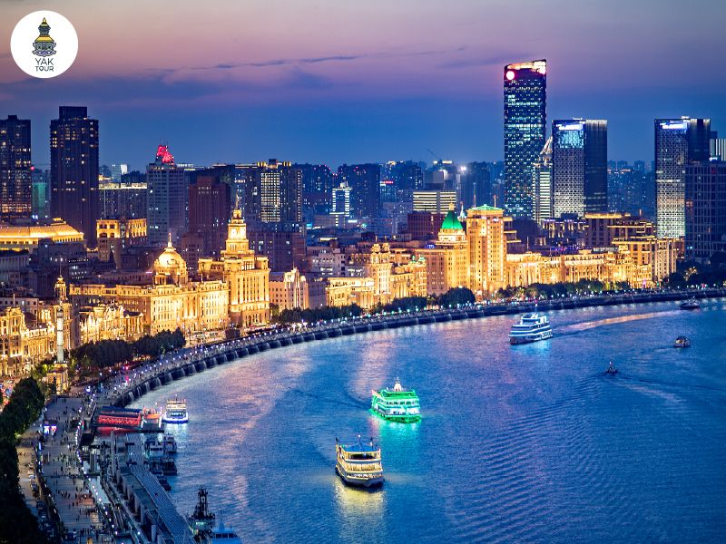 วิวพาโนรามาย่านเดอะบันด์ริมแม่น้ำหวงผู่ยามค่ำคืนที่เต็มไปด้วยแสงไฟจากกลุ่มอาคารสถาปัตยกรรมตะวันตก