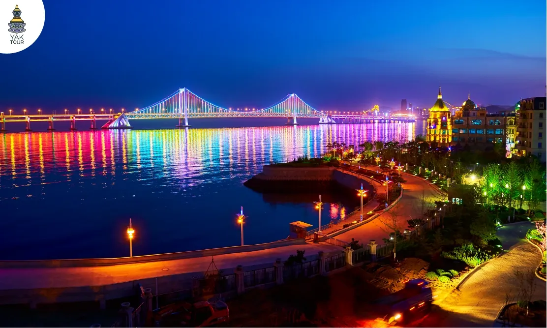 สะพานอ่าวซิงไห่ข้ามทะเลตอนกลางคืนที่เปิดไฟประดับสีสันสะท้อนบนผิวน้ำ