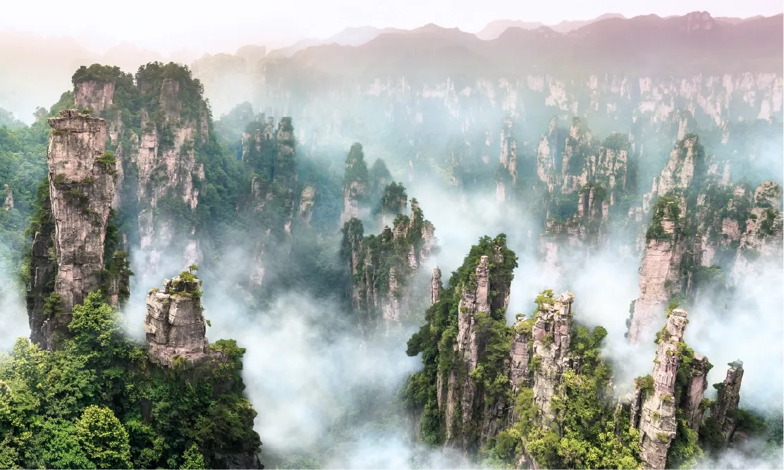 แท่งภูเขาหินทรายสูงเสียดฟ้าท่ามกลางสายหมอกจางเจียเจี้ย